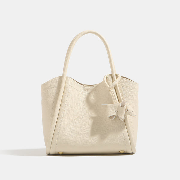 Small structured pebbled leather-look bucket tote bag with bow charm tie closure and gold-tone hardware, detail view 7