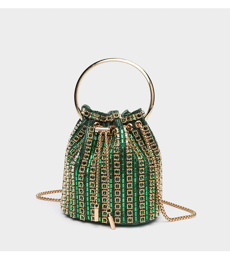 Mini crystal rhinestone bucket bag with circular ring top handle, drawstring closure, and silver chain shoulder strap, detail
