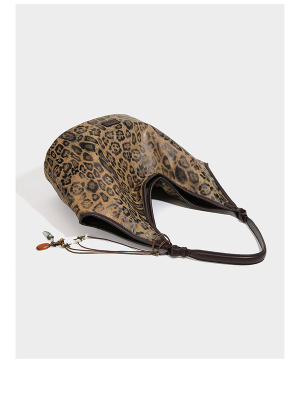 Large slouchy leopard-print shoulder tote bag with glossy tan-and-brown finish, dark brown leather-look trim, single