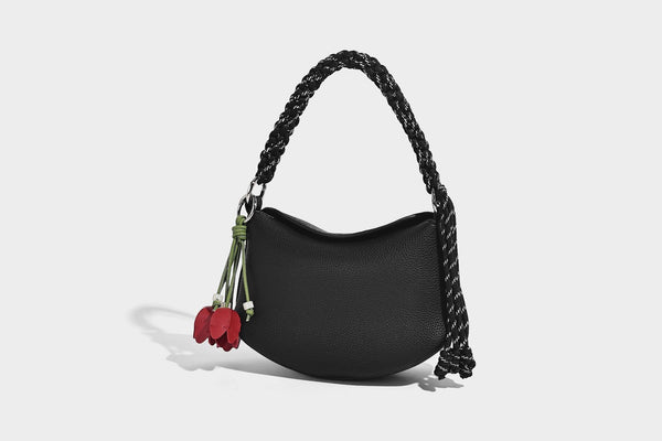 Small crescent half-moon bag in pebbled leather-look finish with braided top handle, silver-tone ring hardware, and, detail