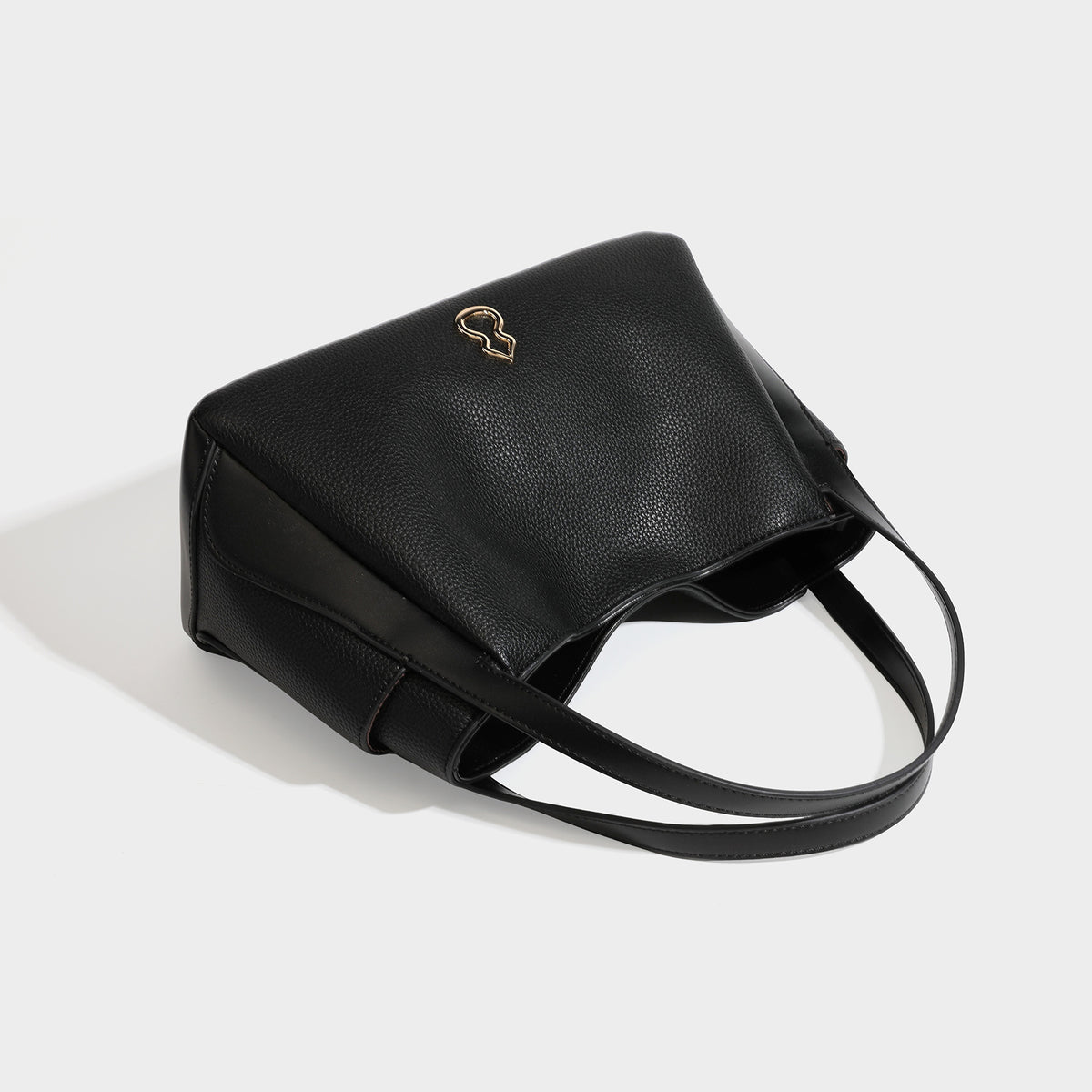 Schwarze Tote-Bag in genarbter Lederoptik mit kürbisförmigen Beschlägen in Goldoptik, zwei Tragegriffen und abnehmbarem Crossbody-Schulterriemen, Detailansicht