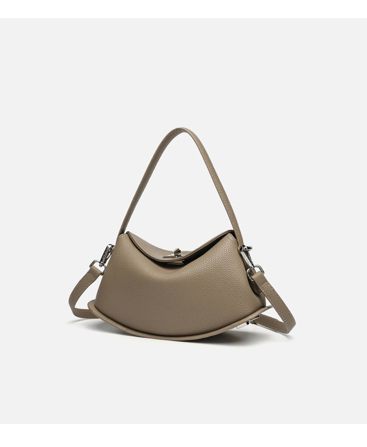 Pebbled leather-look half-moon saddle bag with turn-lock flap closure, top handle, and detachable crossbody strap, detail