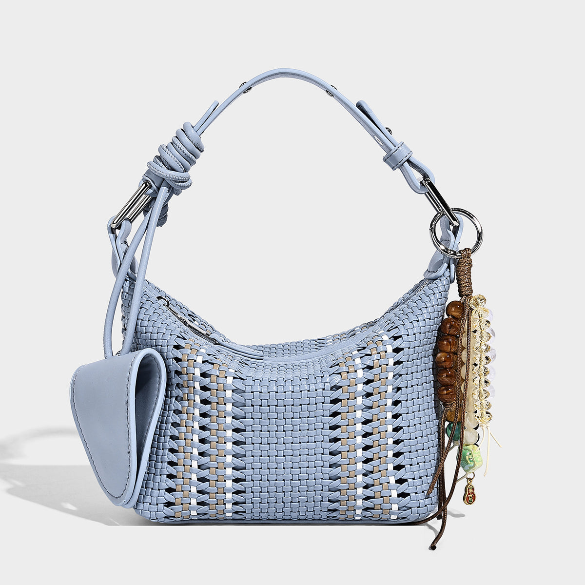 Small woven crescent shoulder bag with leather-look trim, zip closure, silver-tone ring hardware, and beaded tassel charm