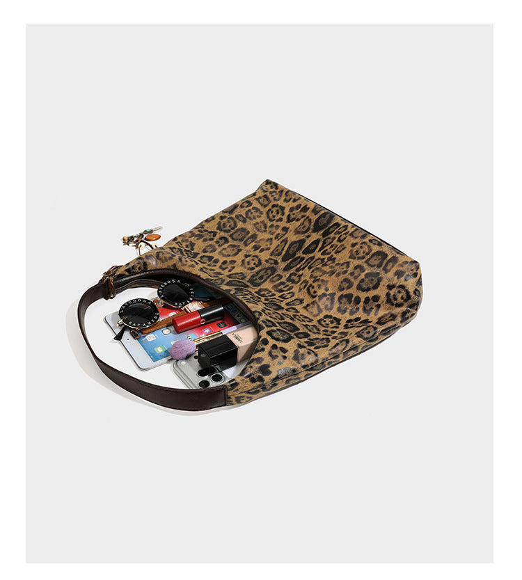 Weich fallende Hobo-Tote-Bag mit Leopardenmuster in Beige und Braun, dunkelbraunem Riemen in Lederoptik und herabhängenden Perlenanhänger-Beschlägen