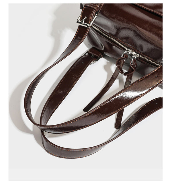 Strukturierte Schultertasche aus glänzendem Lederimitat mit abgerundetem Korpus, silberfarbenen Metalldetails, Reißverschlussfach vorne und Leopardenmuster
