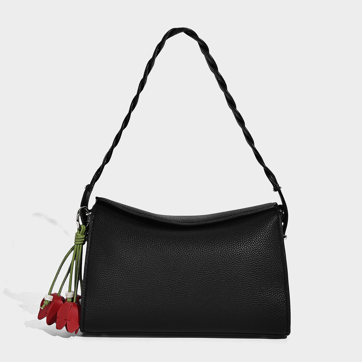 Small structured pebbled-finish shoulder bag with braided top handle, detachable crossbody strap, floral tassel charm, and