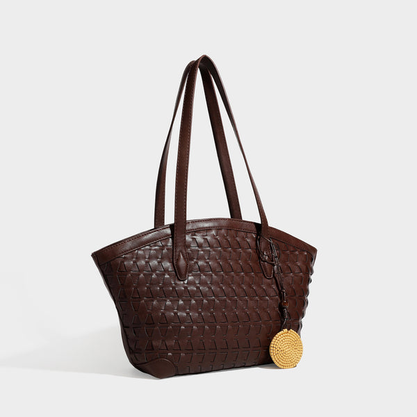 Large leather-look tote bag with geometric woven emboss, double shoulder straps, and round woven cord charm in brown, front