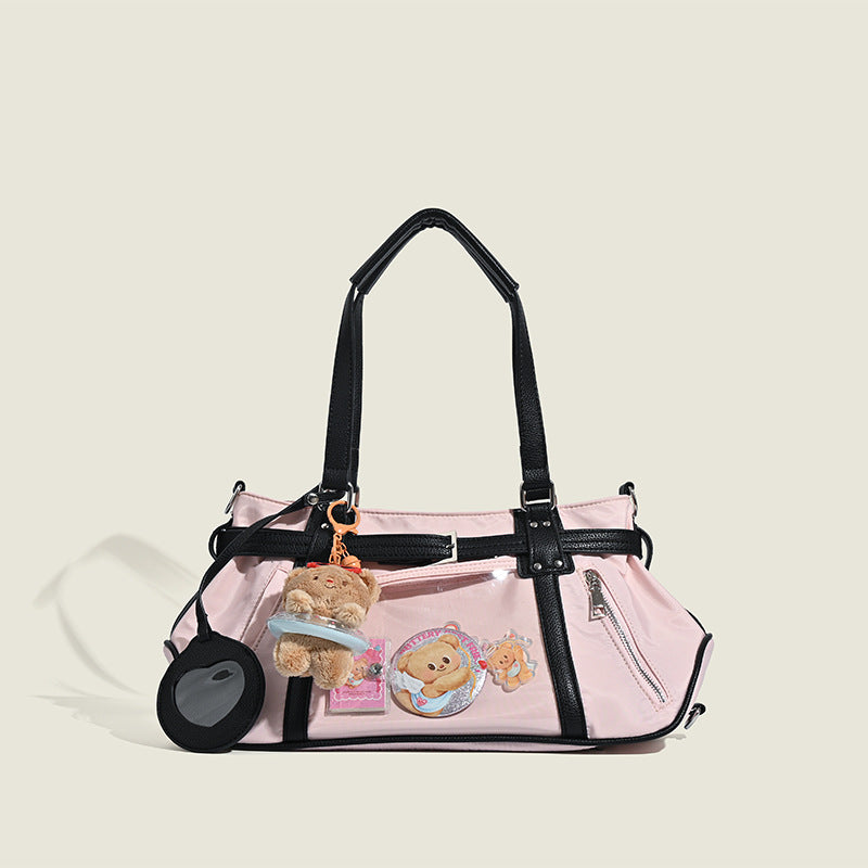 Pale pink nylon tote bag with black leather-look trim, double top handles, side zip pocket, and detachable crossbody strap