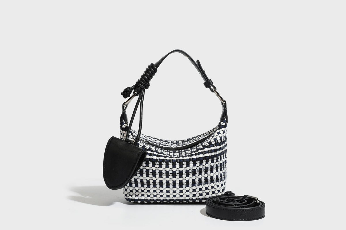 Small crescent shoulder bag in black-and-white woven textile with smooth black leather-look trim, zip-top closure, knotted