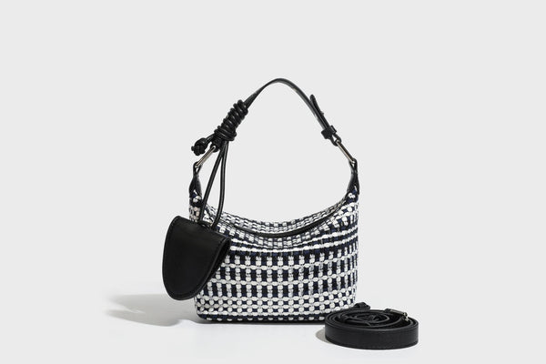 Small crescent shoulder bag in black-and-white woven textile with smooth black leather-look trim, zip-top closure, knotted