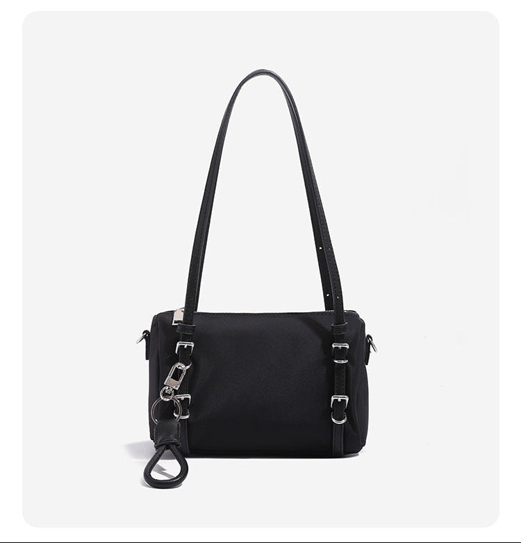 Compact nylon Boston barrel bag with zip-top closure, silver-tone hardware, dual slim handles, and detachable crossbody