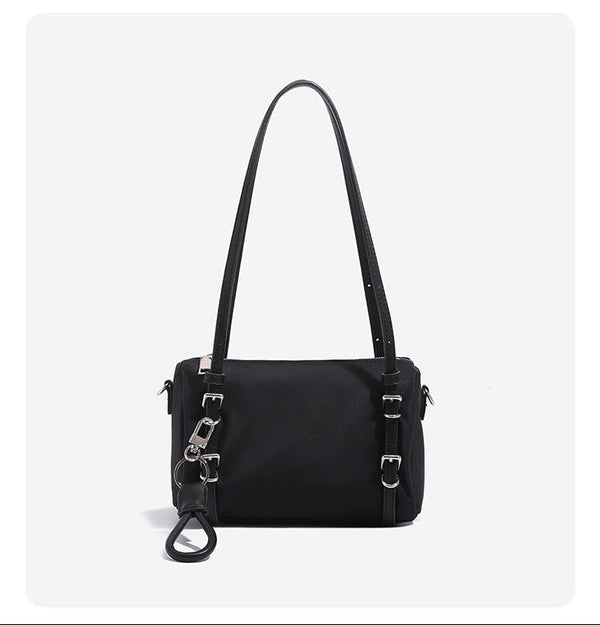 Compact nylon Boston barrel bag with zip-top closure, silver-tone hardware, dual slim handles, and detachable crossbody