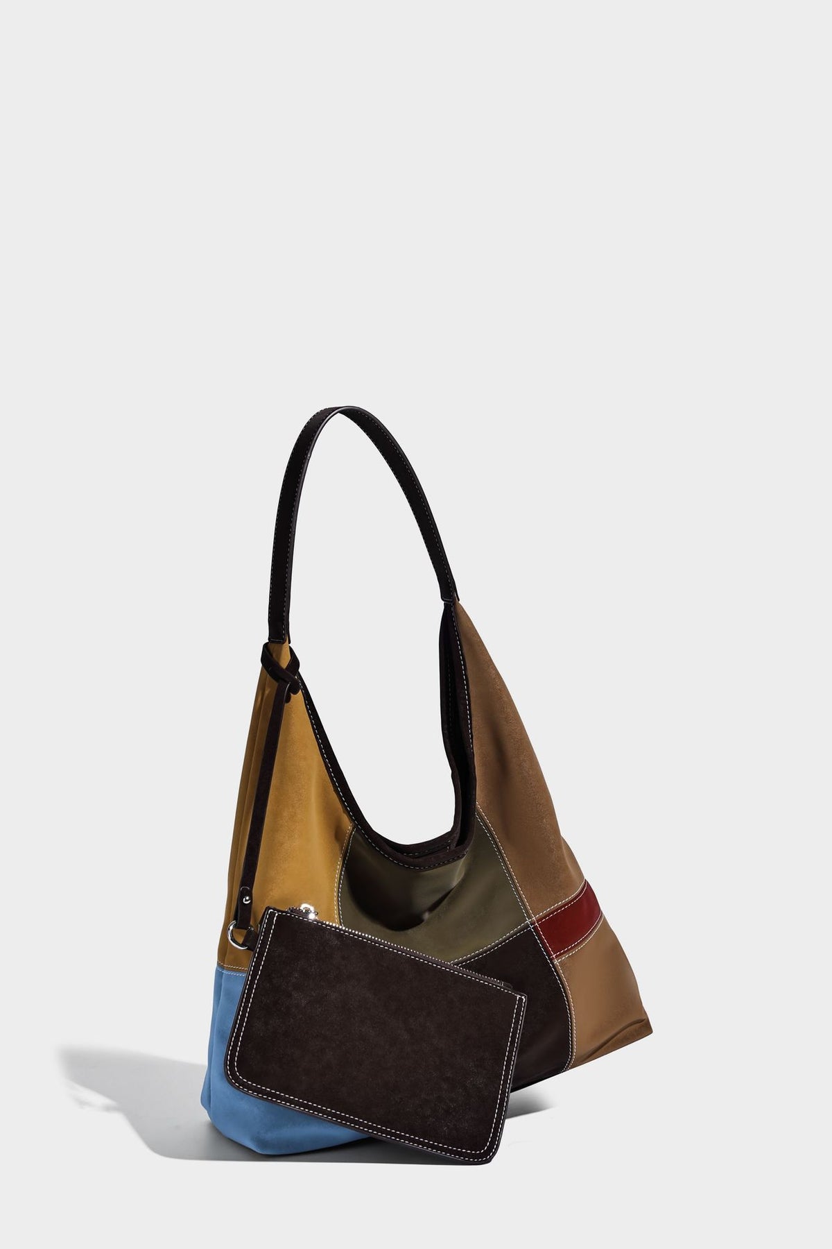 Multicolor patchwork hobo shoulder bag with brown tan olive mustard red and blue suede-look panels, contrast white stitching