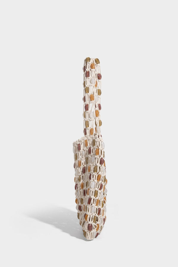 Cream macramé open-weave tote bag with multicolor amber olive and translucent bead accents and woven shoulder straps, detail