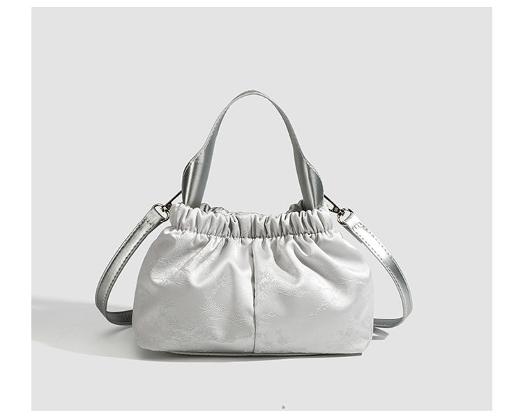 Small ruched satin-finish cloud bag with elasticized drawstring top, short top handle, and chunky silver-tone chain strap