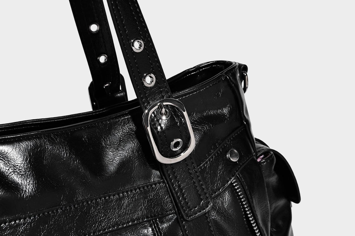 Glossy structured black tote shoulder bag with silver buckle hardware, zip pockets, dual top handles, and detachable, detail