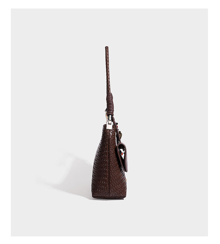 Woven-texture hobo shoulder bag in brown with braided top handle, adjustable crossbody strap, front flap pocket, and, detail