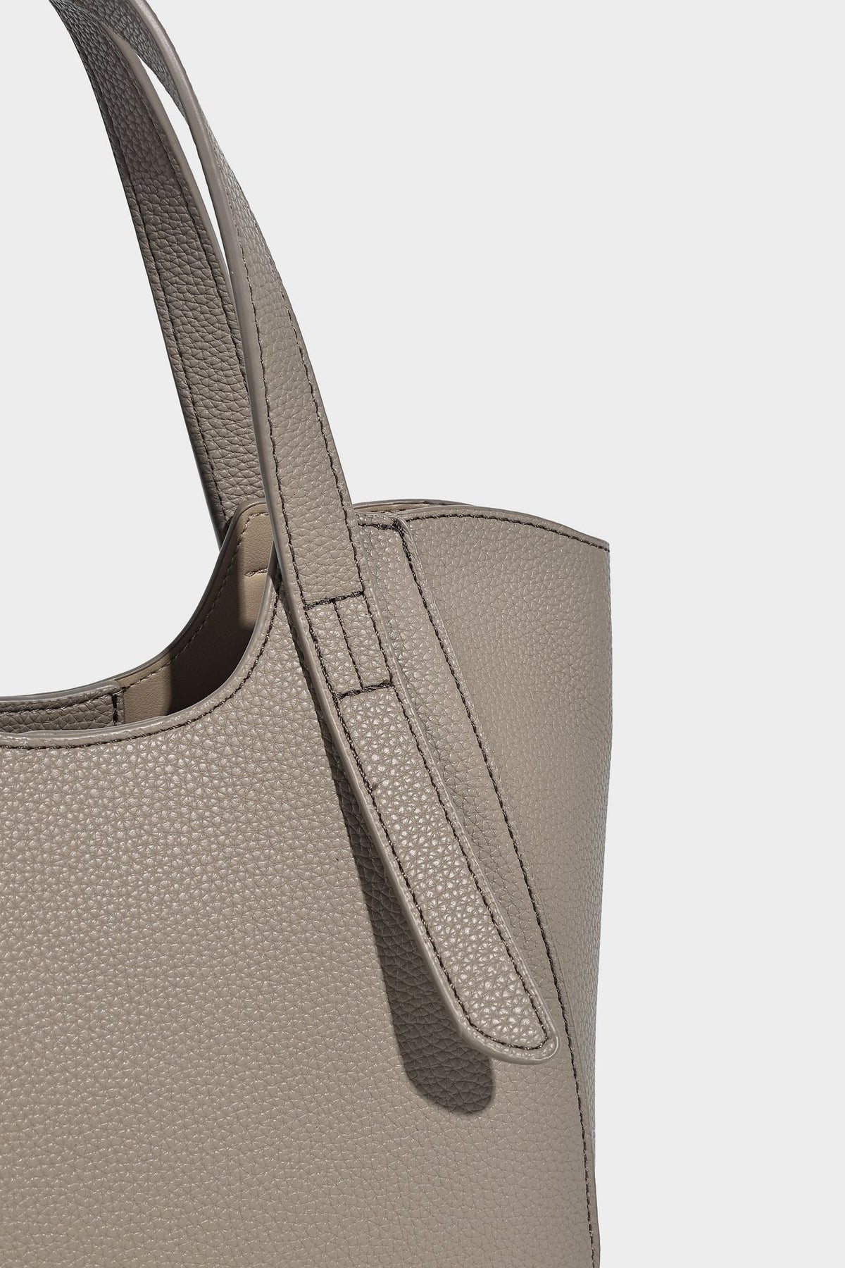 Structured pebbled leather-look tote bag with detachable scarf tie, dual top handles, and adjustable crossbody strap, detail