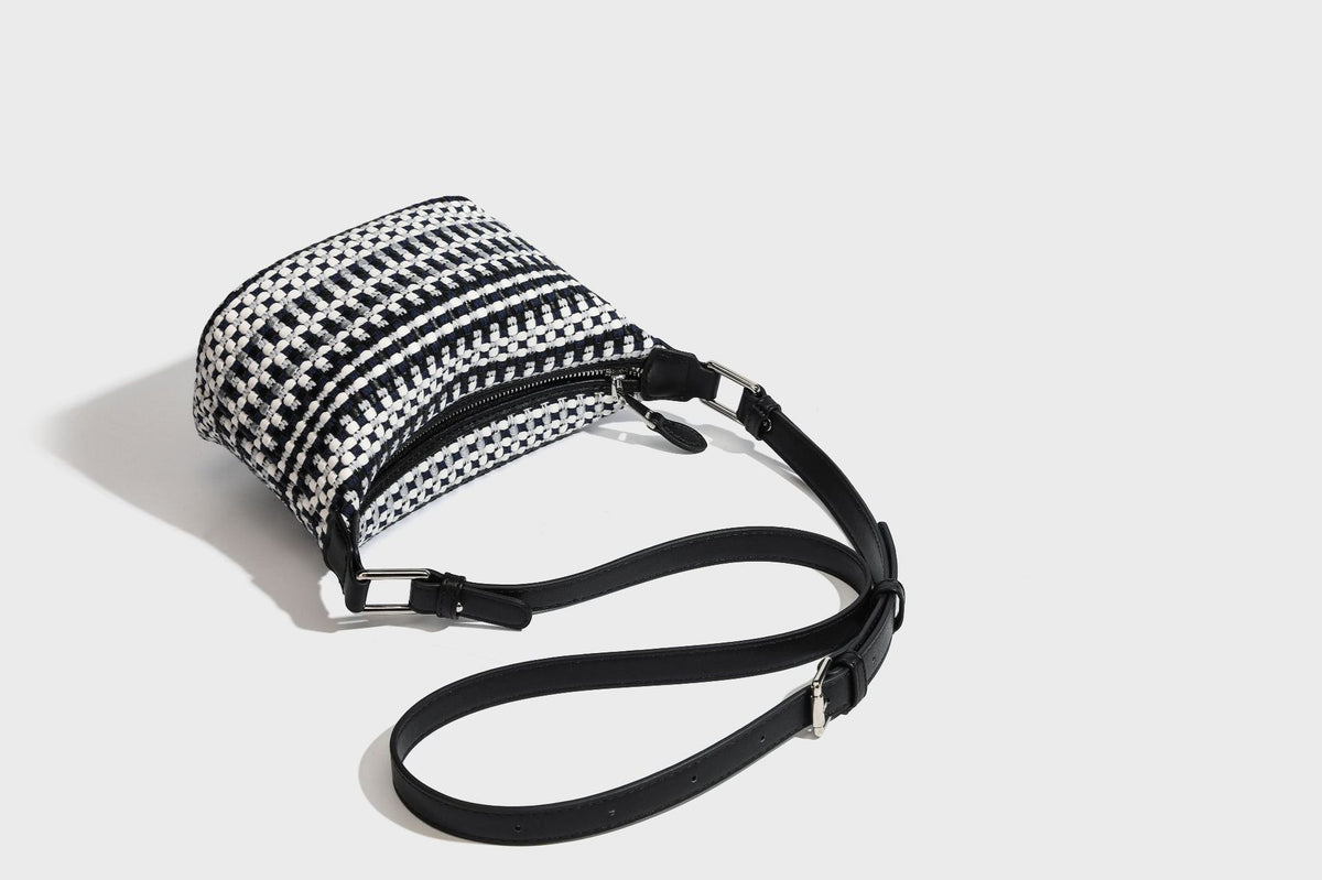 Small crescent shoulder bag in black-and-white woven textile with smooth black leather-look trim, zip-top closure, knotted