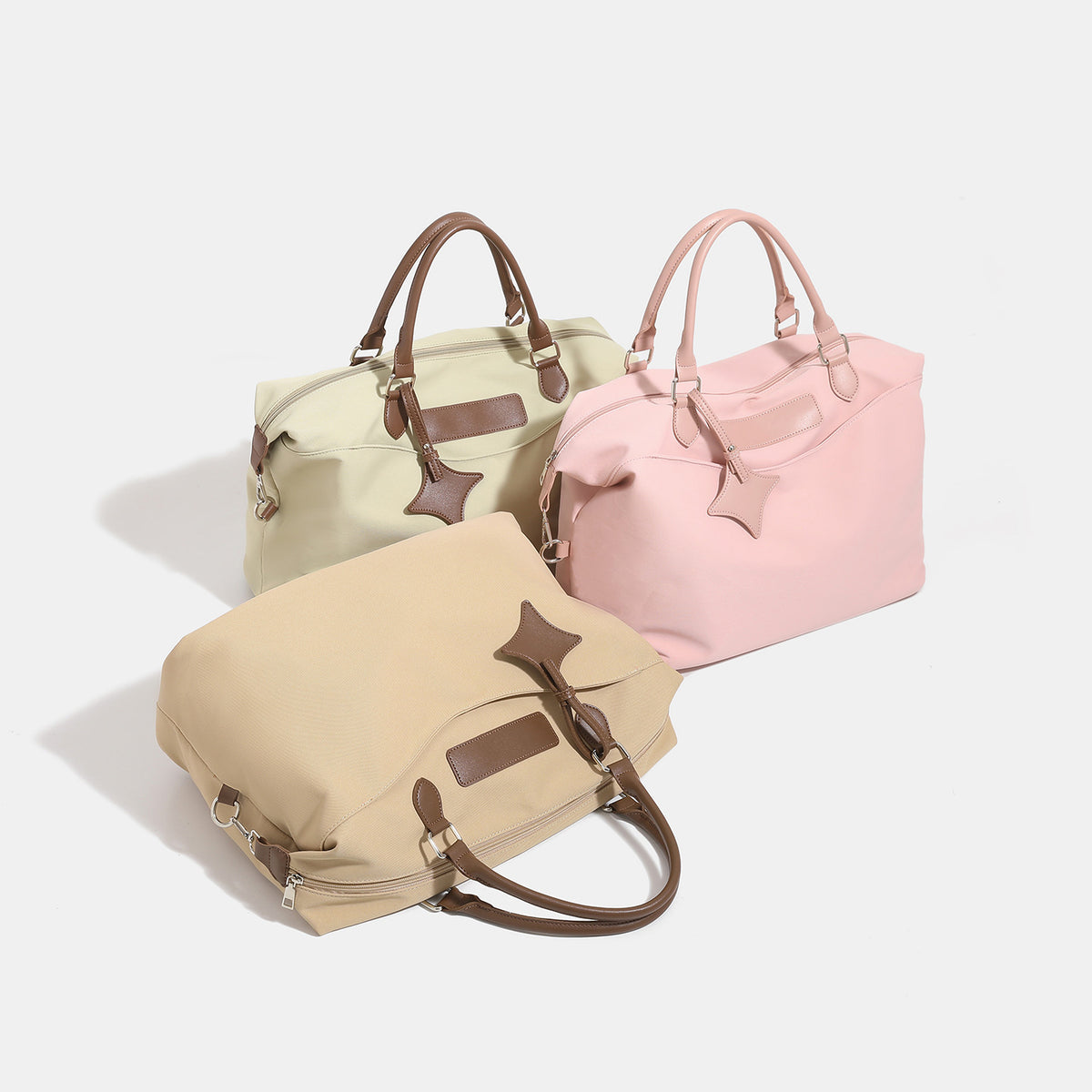 Large slouchy nylon tote bag with brown leather-look handles, double-pull zip closure, and star charm detail, detail view 2