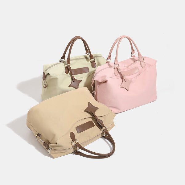 Large slouchy nylon tote bag with brown leather-look handles, double-pull zip closure, and star charm detail, detail view 2