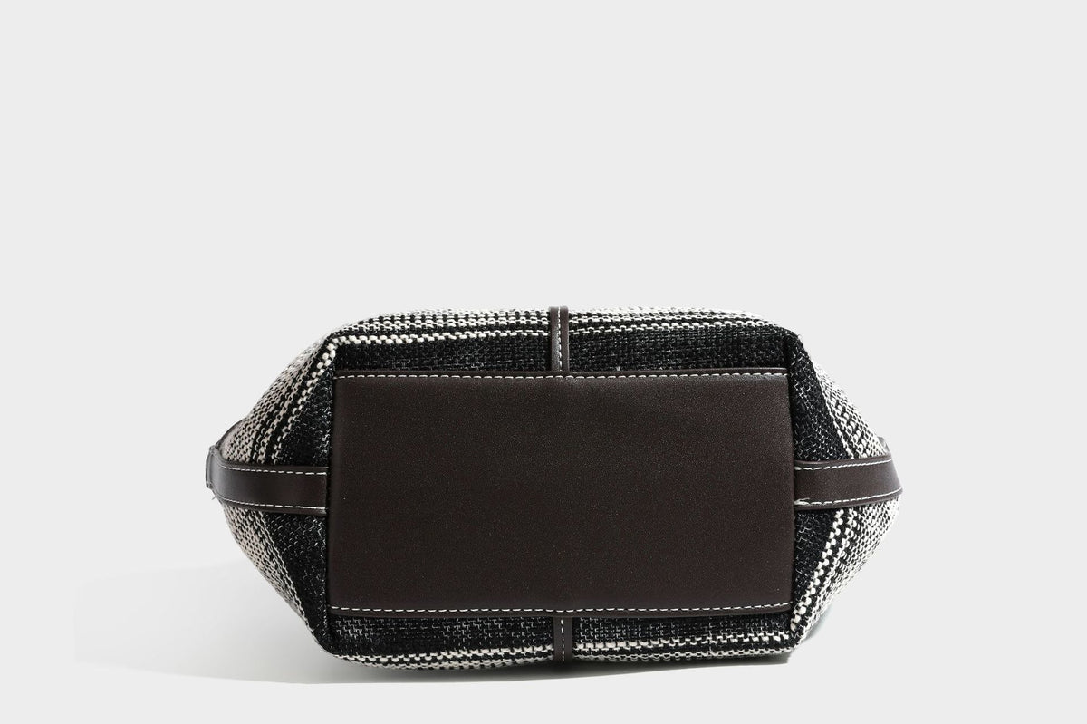 Schwarz-weiße gewebte Trapez-Tote-Bag mit dunklem Lederimitat-Besatz, weißen Kontrastnähten und zwei Henkeln, Detailansicht