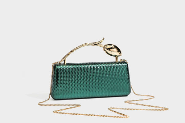 Structured rectangular metallic woven clutch bag with sculptural gold-tone leaf top handle and detachable chain strap, detail
