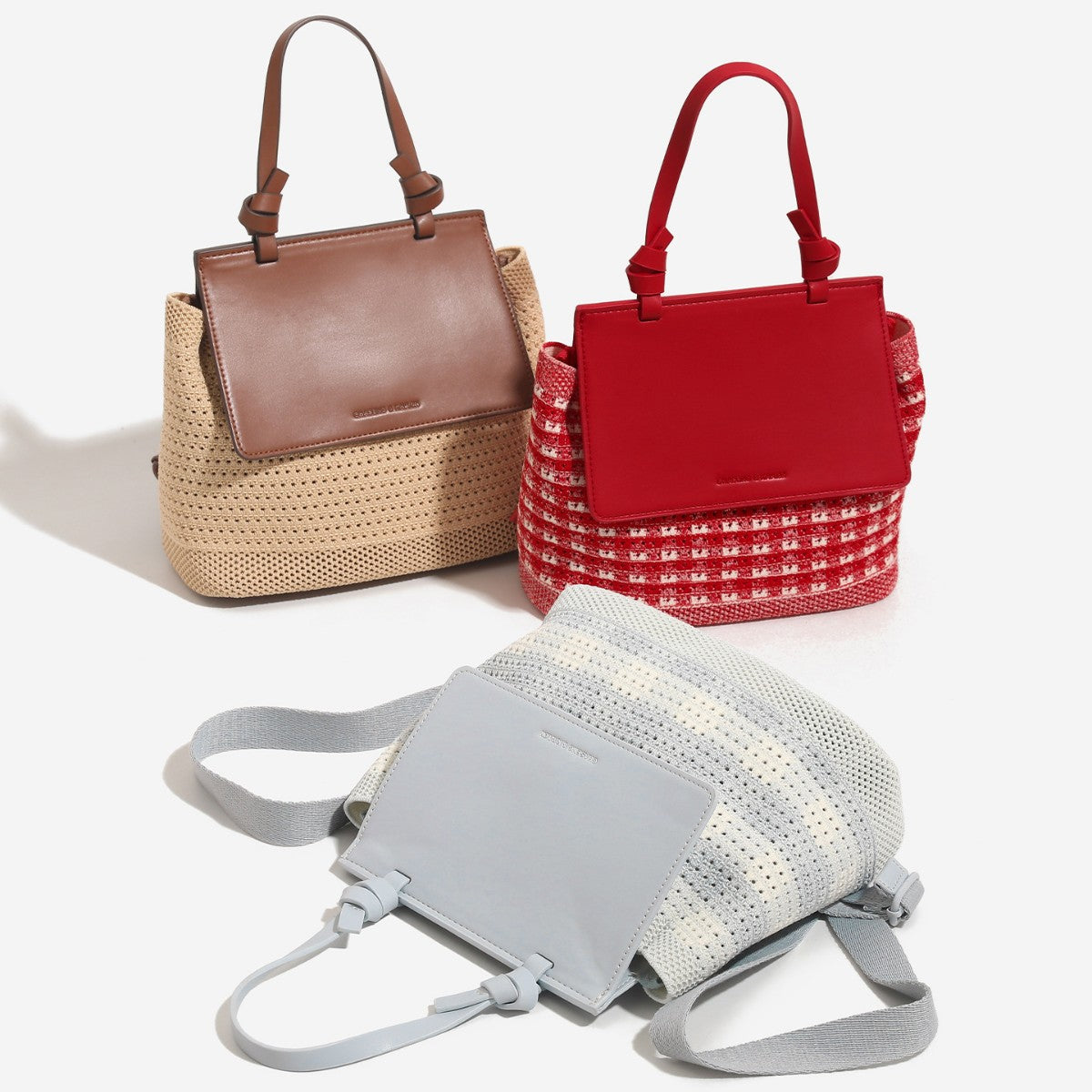Small structured woven-body flap bag with smooth leather-look front panel, knotted top handle, and wide adjustable shoulder