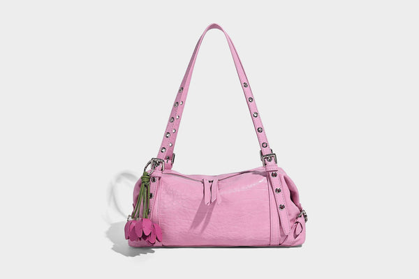 Pale yellow leather-look barrel bag with silver grommet-studded shoulder straps, top zip closure, and pink tulip floral
