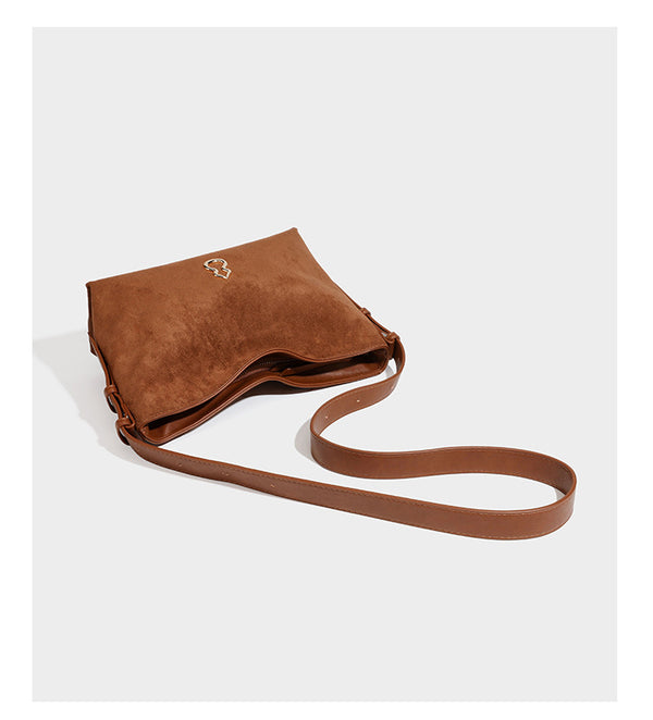 Slouchy suede-finish brown shoulder bag with long single strap and small gold-tone logo emblem on front, detail view 13