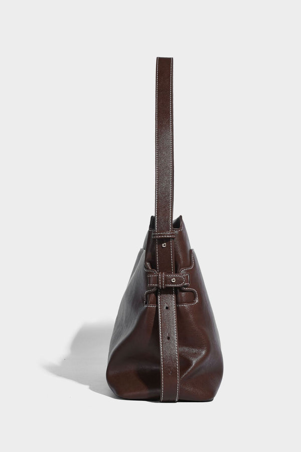Large slouchy leather-look hobo tote bag with open top, adjustable shoulder strap, and colorful tassel bead charm, detail