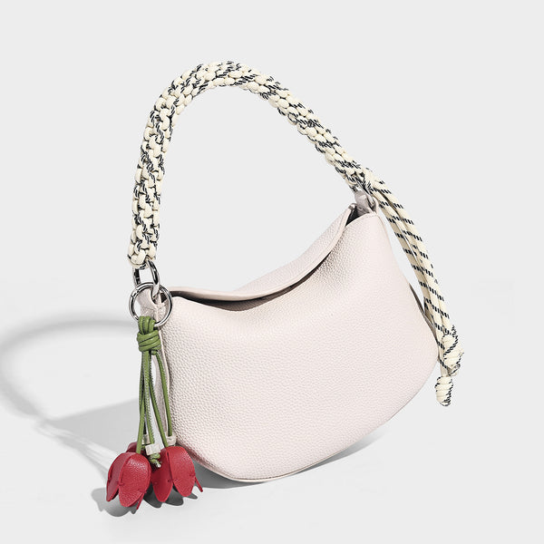 Small crescent half-moon bag in pebbled leather-look finish with braided top handle, silver-tone ring hardware, and, detail