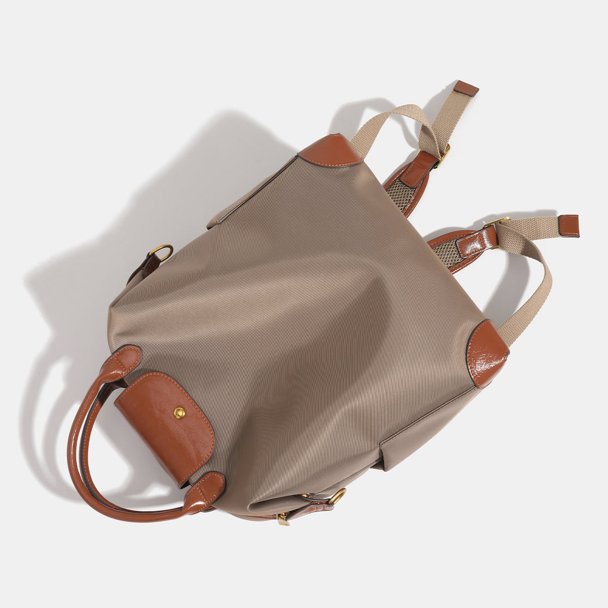 Soft rectangular nylon convertible backpack handbag with leather-look trim, snap-flap closure, top carry handles, padded