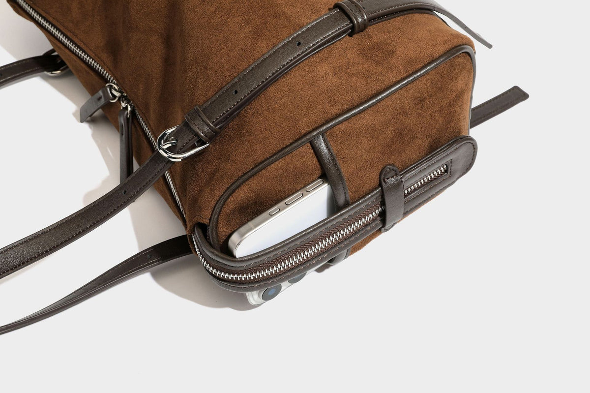 Large brown suede-finish barrel shoulder bag with dark leather-look trim, silver-tone zippers, dual top handles, and long