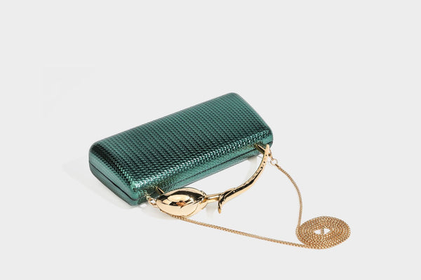 Structured rectangular metallic woven clutch bag with sculptural gold-tone leaf top handle and detachable chain strap, detail
