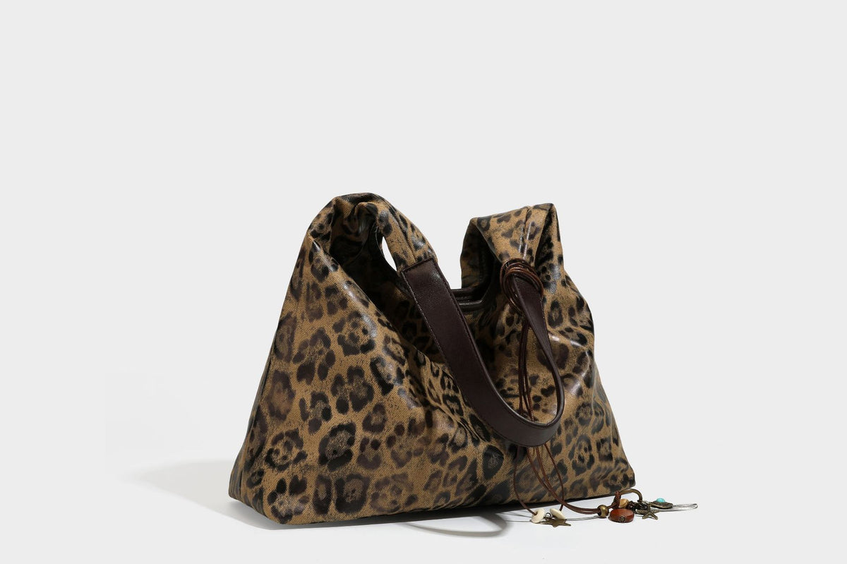 Weich fallende Hobo-Tote-Bag mit Leopardenmuster in Beige und Braun, dunkelbraunem Riemen in Lederoptik und herabhängenden Perlenanhänger-Beschlägen