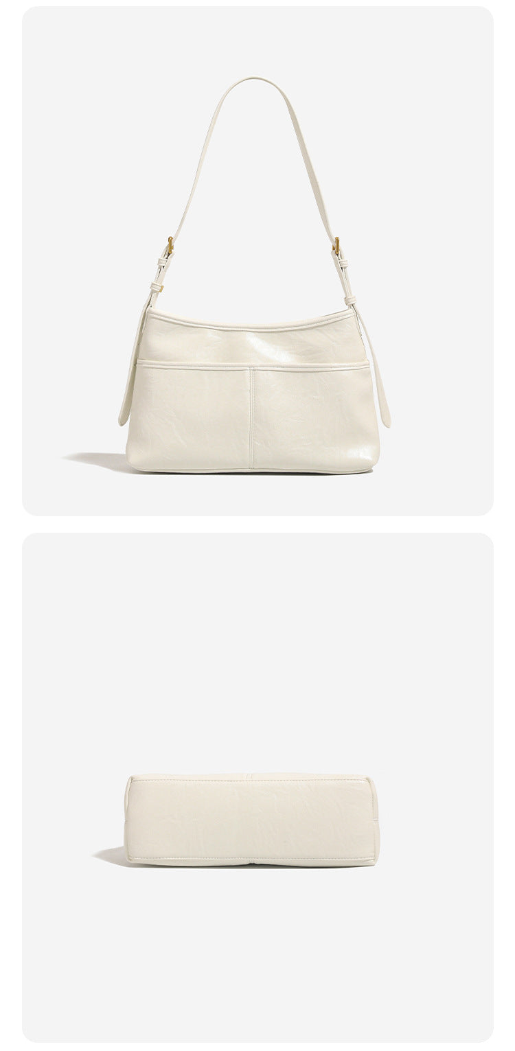 Relaxed leather-look shoulder tote bag in cream white with front exterior pocket, gold-tone ring hardware, and adjustable