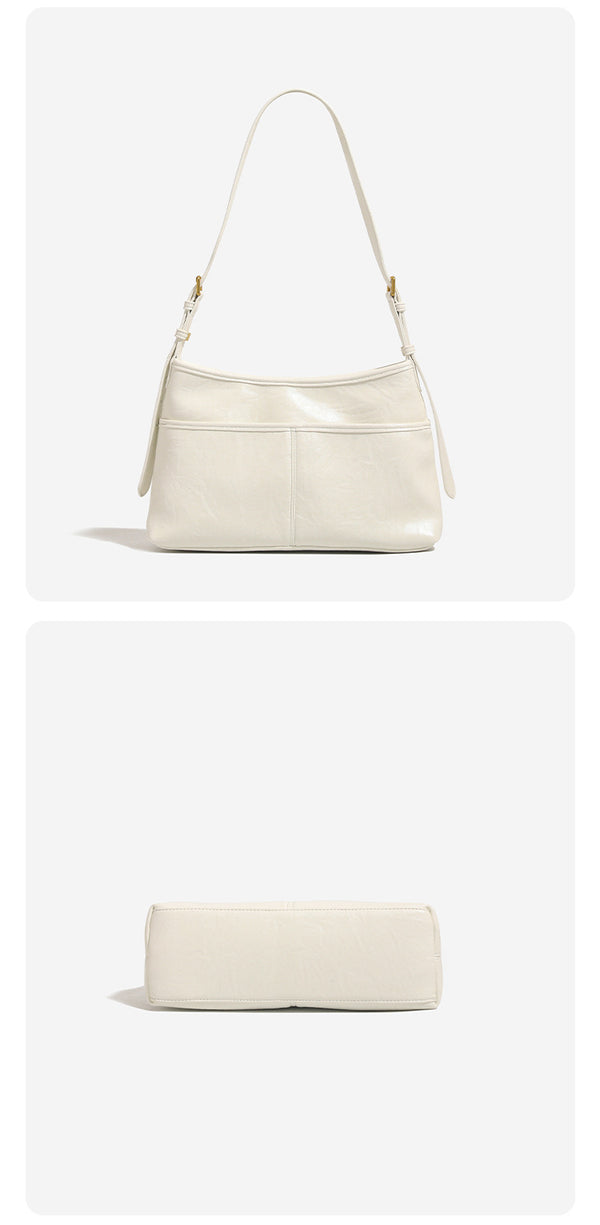 Relaxed leather-look shoulder tote bag in cream white with front exterior pocket, gold-tone ring hardware, and adjustable