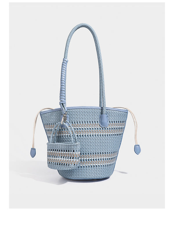 Structured woven bucket tote bag in pastel blue with braided shoulder strap, open lattice weave body, cream drawstring