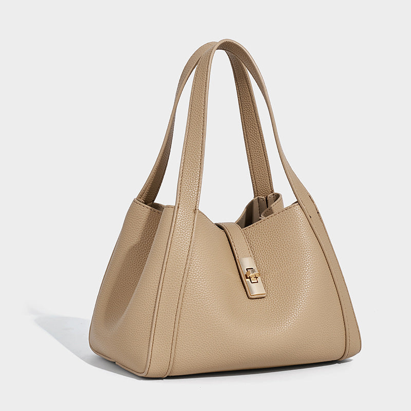 Structured trapezoid tote bag in taupe pebbled leather-look finish with gold-tone turn-lock hardware, dual top handles, and
