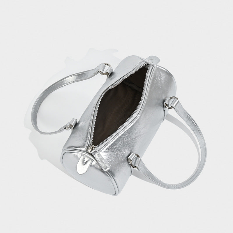 Mini silver barrel bag with crinkled leather-look finish, top handles, and silver-tone hardware, detail view 4