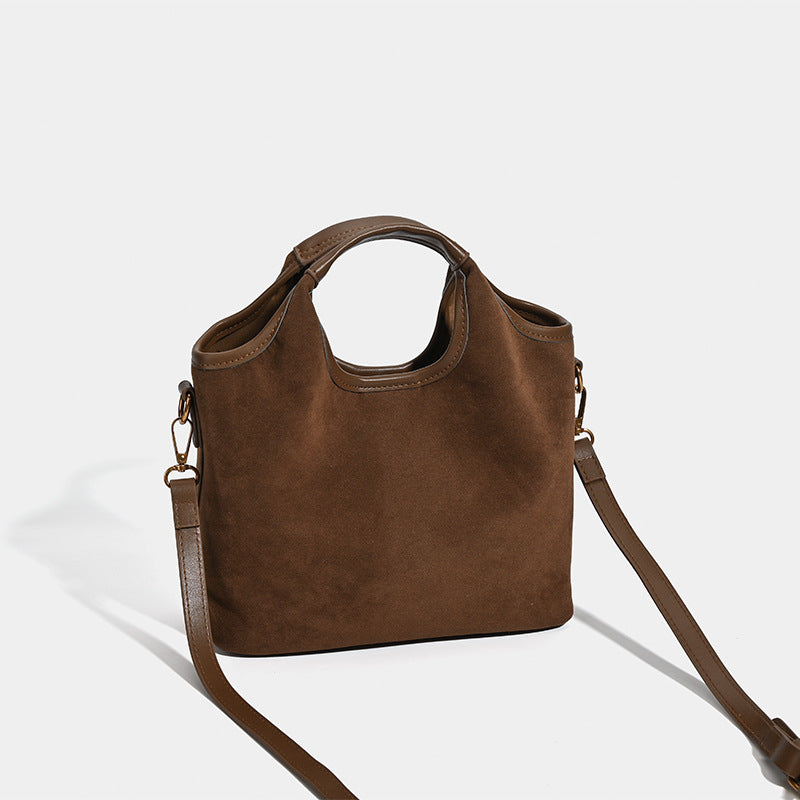 Wandelbarer Shopper in mattem Schokoladenbraun mit Velourslederoptik, abgerundeten Henkeln und abnehmbarem Schulterriemen, goldfarbene Details