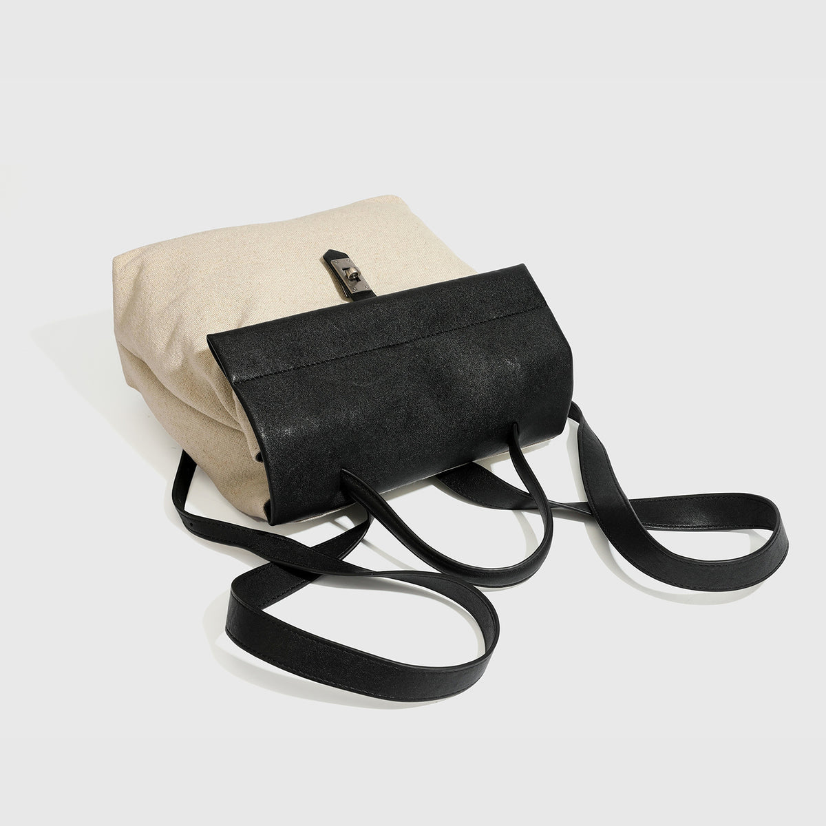 Strukturierter Rucksack in beige aus gewebtem Canvas mit schwarzer Klappe in Lederoptik, Drehverschluss, Tragegriff und flachem Schulter