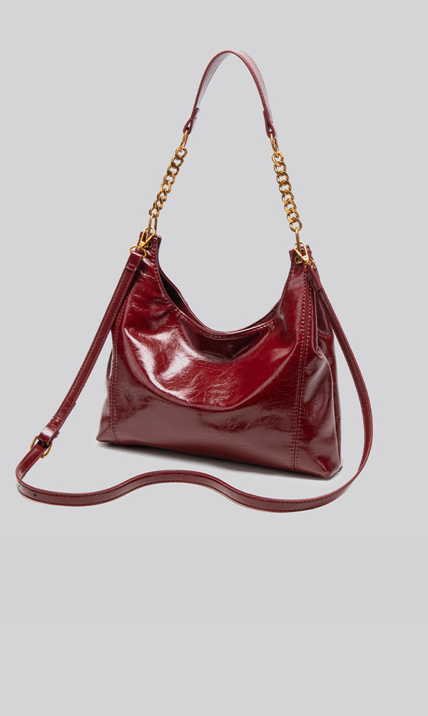 Glossy leather-look hobo shoulder bag with gold-tone chain-and-leather strap in deep burgundy red, detail view 13