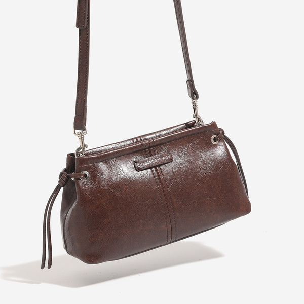 Small retro convertible shoulder bag with glossy leather-look finish, side drawstring ties, top zip closure, and silver-tone