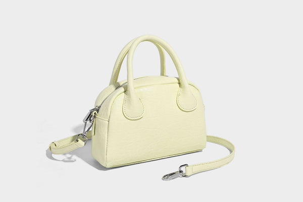 Mini-Tasche mit strukturierter Kuppelform und Tragegriff, in Pastellgelb mit genarbter Lederoptik, silberfarbenen Metallbeschlägen und abnehmbarem