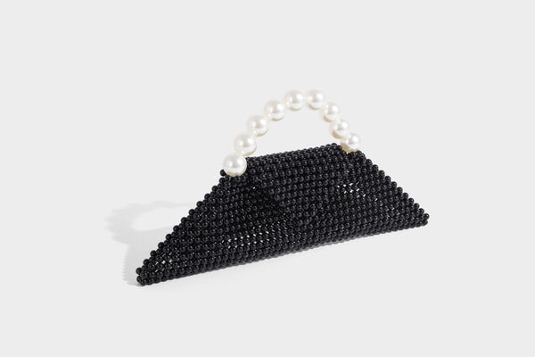 Small structured triangle clutch bag covered in glossy pearl beads with an arched pearl top handle and silver snap closure