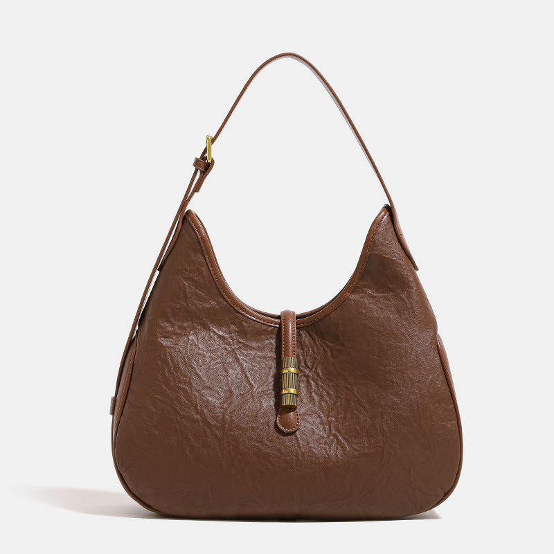 Slouchy teardrop shoulder bag in crinkled leather-look finish with gold-tone tab closure and adjustable strap, detail view 2