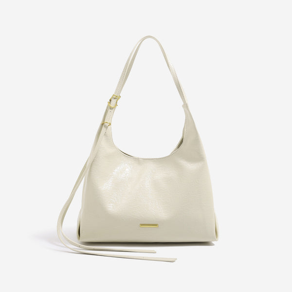 Slouchy hobo shoulder bag in crinkle high-gloss leather-look finish with gold-tone bar hardware and adjustable strap, detail
