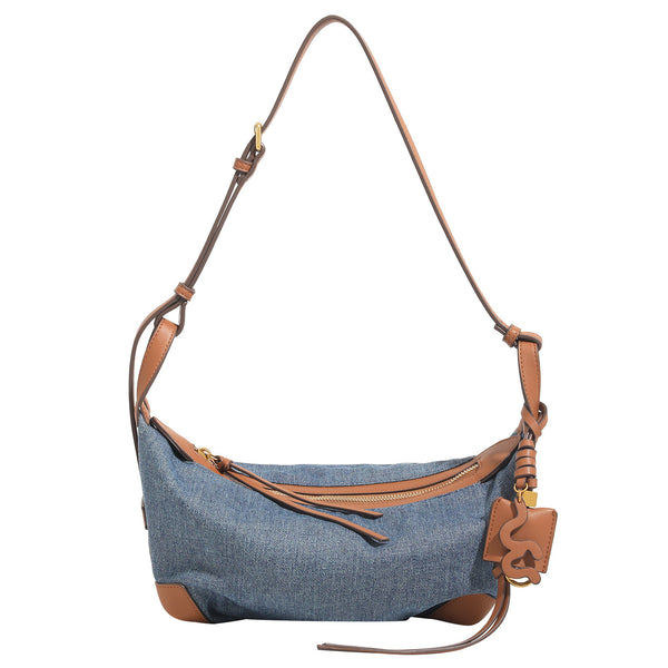 Washed denim canvas crescent hobo bag with tan leather-look trim, knotted strap detail, and gold-tone zipper hardware, detail